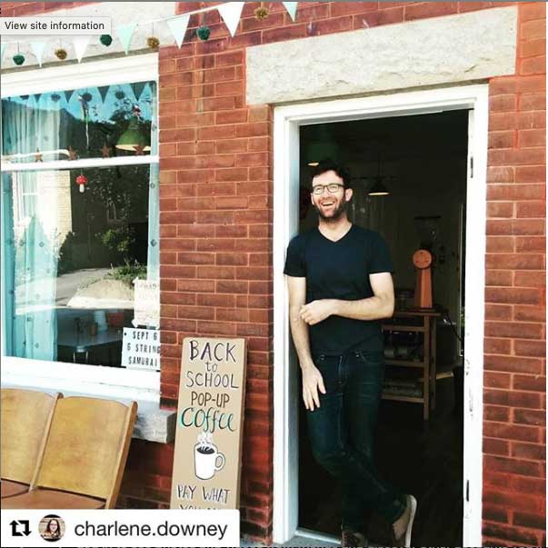 An incredibly handsome man standing in the open doorway of the clubhouse